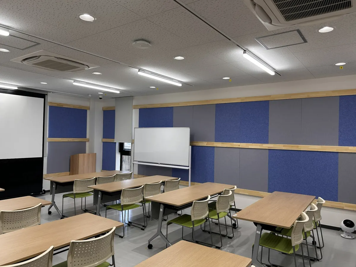 会議室の壁面に青・グレーの吸音パネルを施工した実施工例（側面側）
